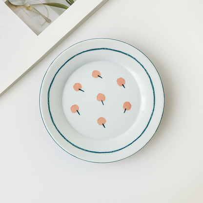 A white ceramic plate with a cherry pattern